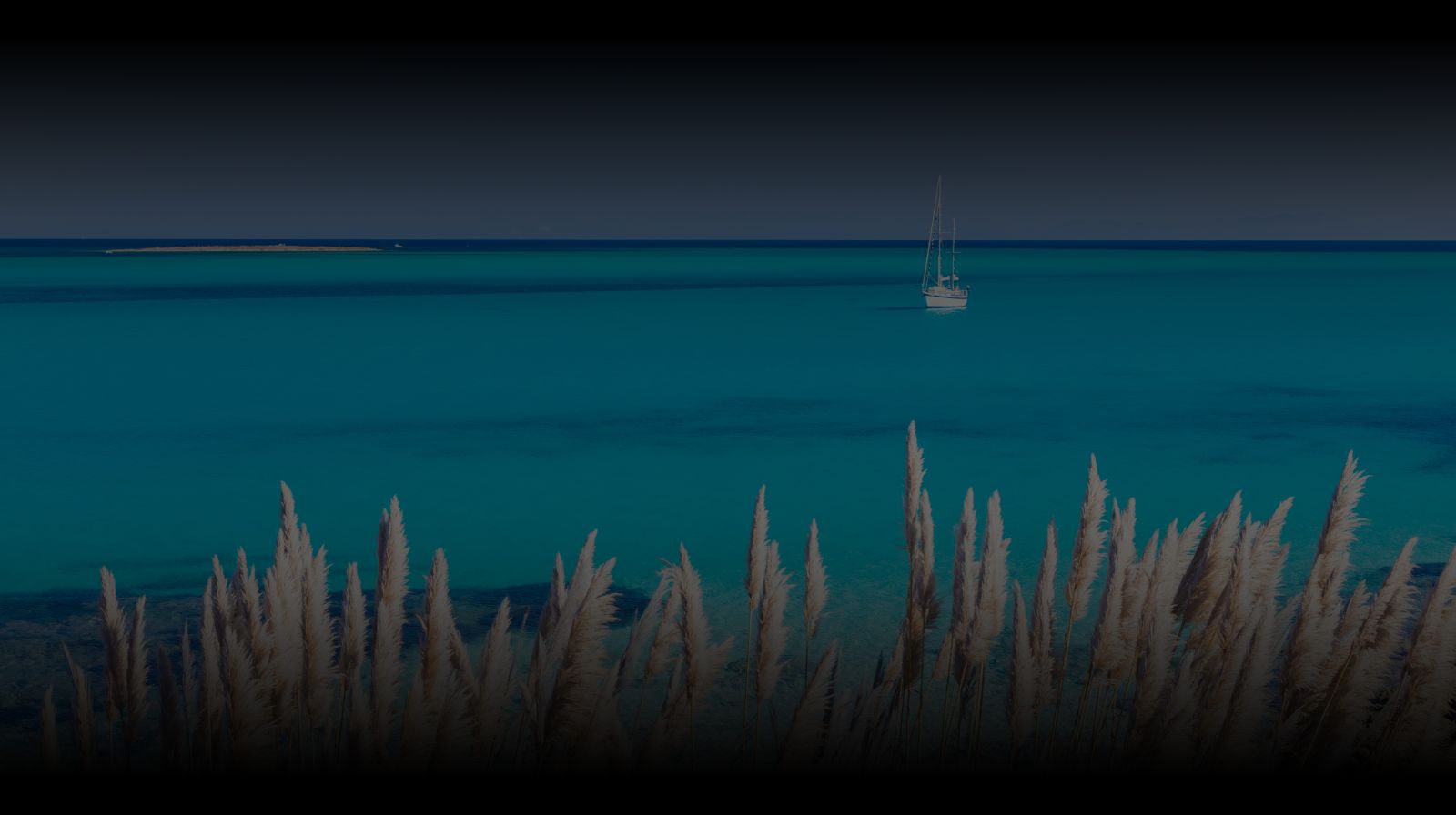 Türkisfarbenes Meer mit Segelboot an der Küste Sardiniens