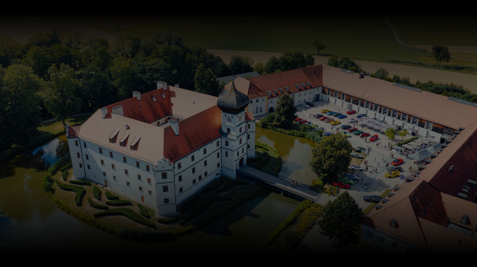 Luftaufnahme des Cruisefire Concorso di Bavaria 2026 mit Sportwagen vor einem Schloss in Bayern